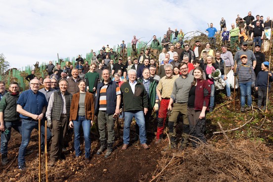 Viele Menschen an einem Hang nachdem sie Bäume gegen den Nationalpark Egge gepflanzt haben